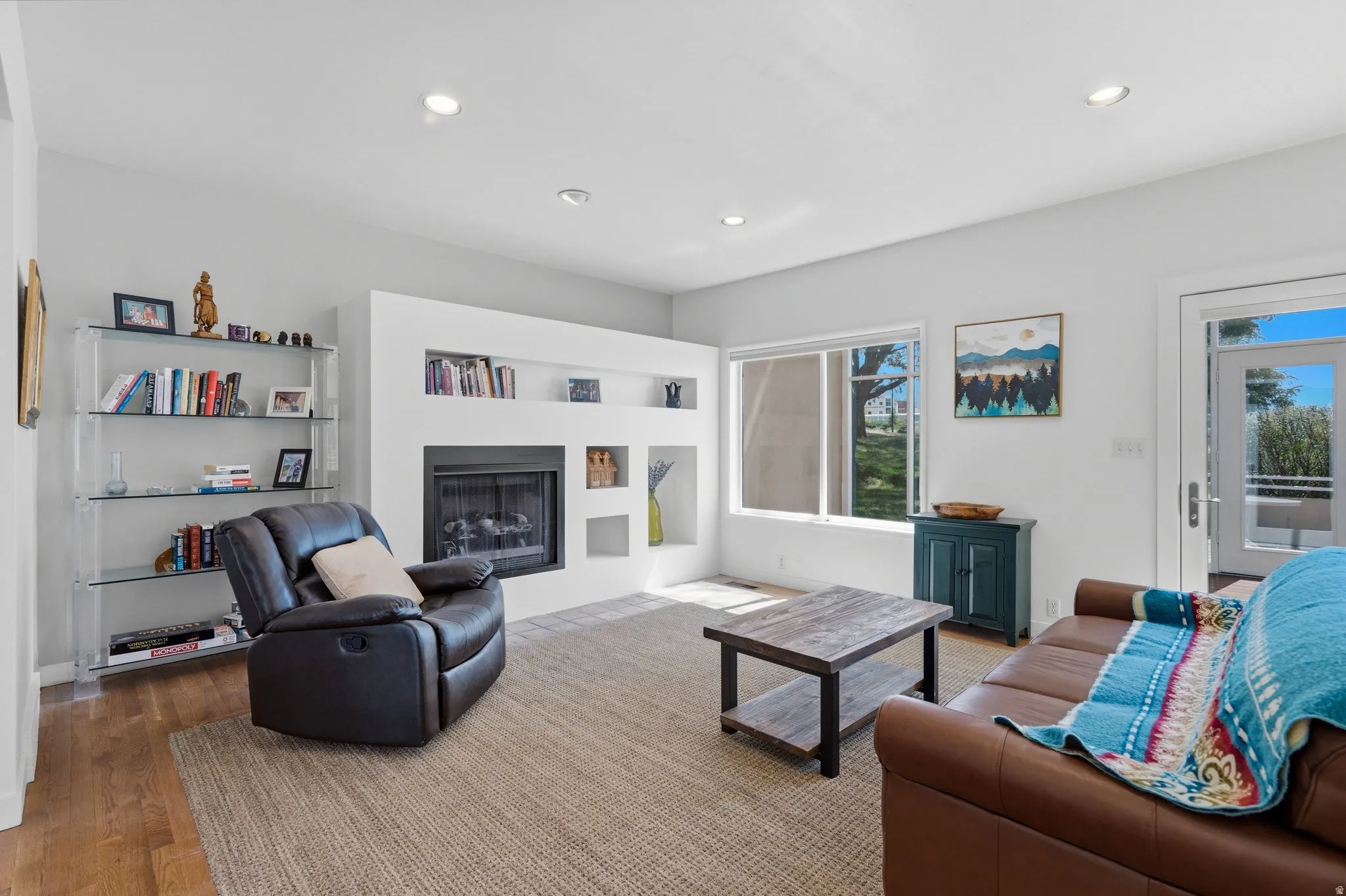 Living area featuring a built-in fireplace, recessed lighting, and wood-finish flooring