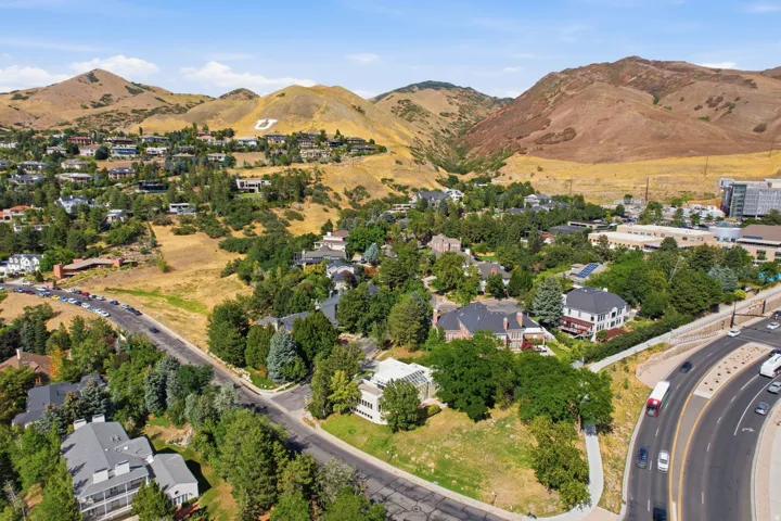 Expansive residential area featuring established homes, mature trees, mountainous terrain, and a prominent "U" landmark on the distant hillside