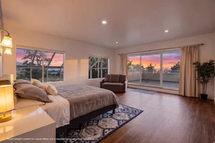 Spacious interior with wood-finish flooring, recessed lighting, and a private balcony