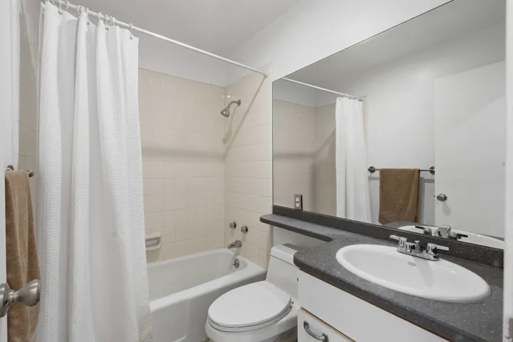Vanity with integrated sink, chrome faucet, and dark countertop