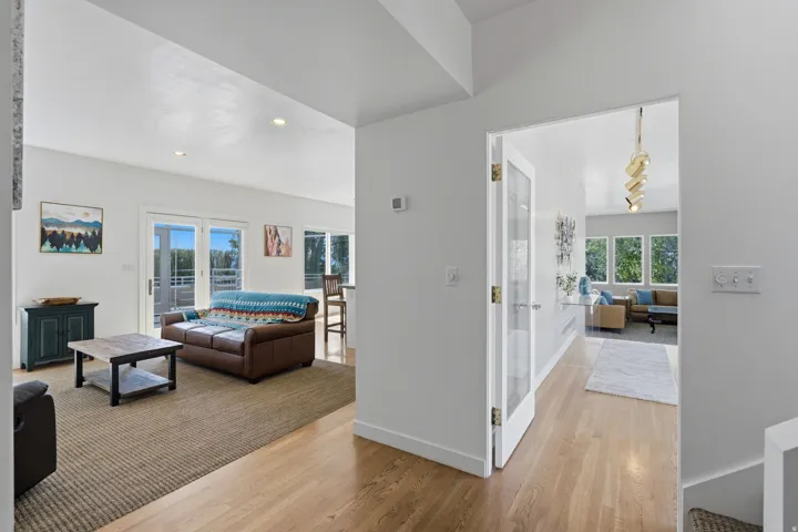 Hardwood flooring throughout, recessed lighting, and a glass-paneled door