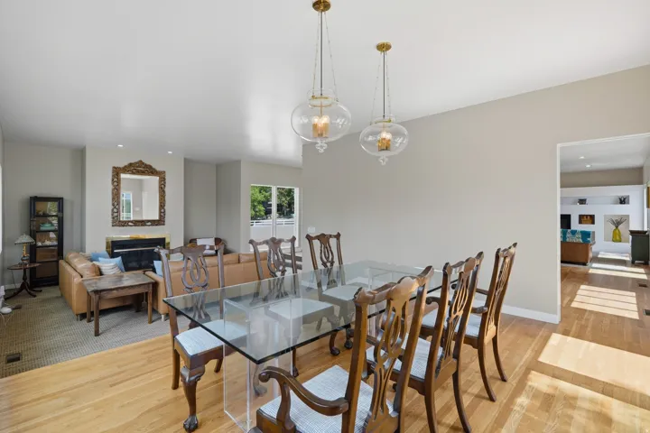 Hardwood flooring throughout, recessed lighting, and a fireplace with a decorative mantel and mirror