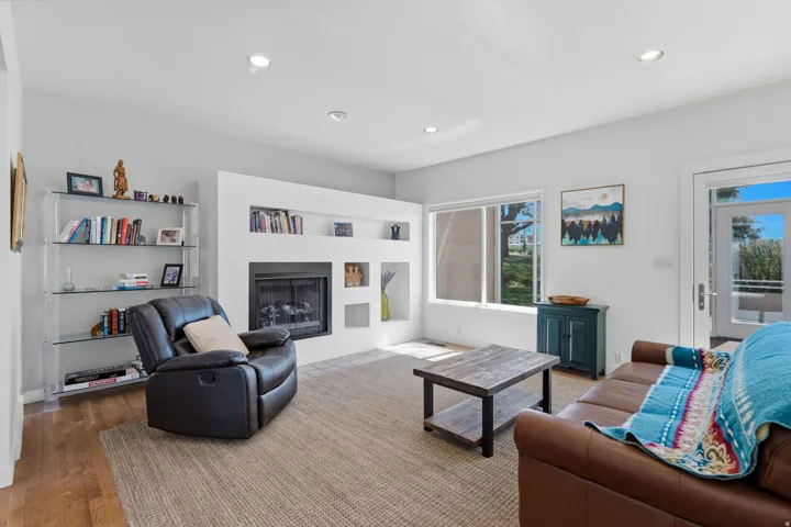 Living area featuring a built-in fireplace, recessed lighting, and wood-finish flooring