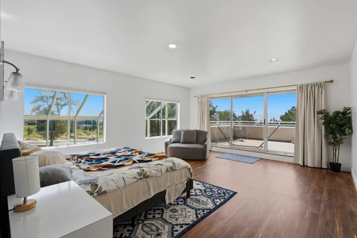 Recessed lighting, wood-finish flooring, multiple windows, and sliding glass doors leading to a private outdoor space