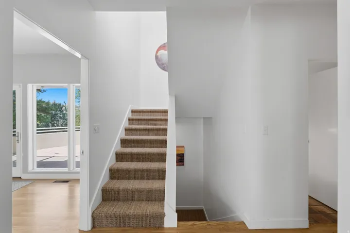 Carpeted staircase with white risers