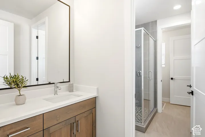 Wood-finish vanity with a rectangular undermount sink, a white countertop, and a framed mirror