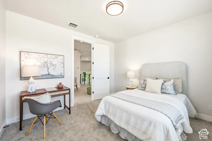 Recessed ceiling light fixture, neutral carpet flooring, and a solid core interior door