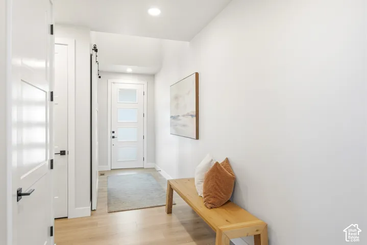 Entryway featuring wood-finish flooring, white walls, and recessed lighting