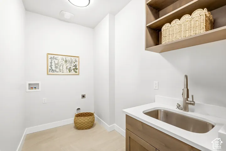Built-in wood-finish cabinetry with open shelving, stainless steel utility sink, and white countertop