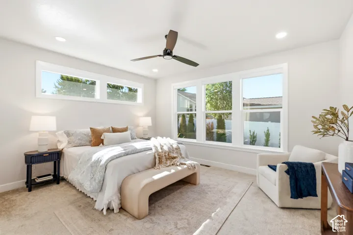 Recessed lighting, ceiling fan, and large windows with white trim