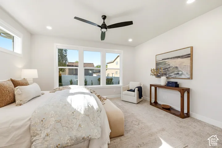 Recessed lighting, ceiling fan, large windows, and neutral carpeting