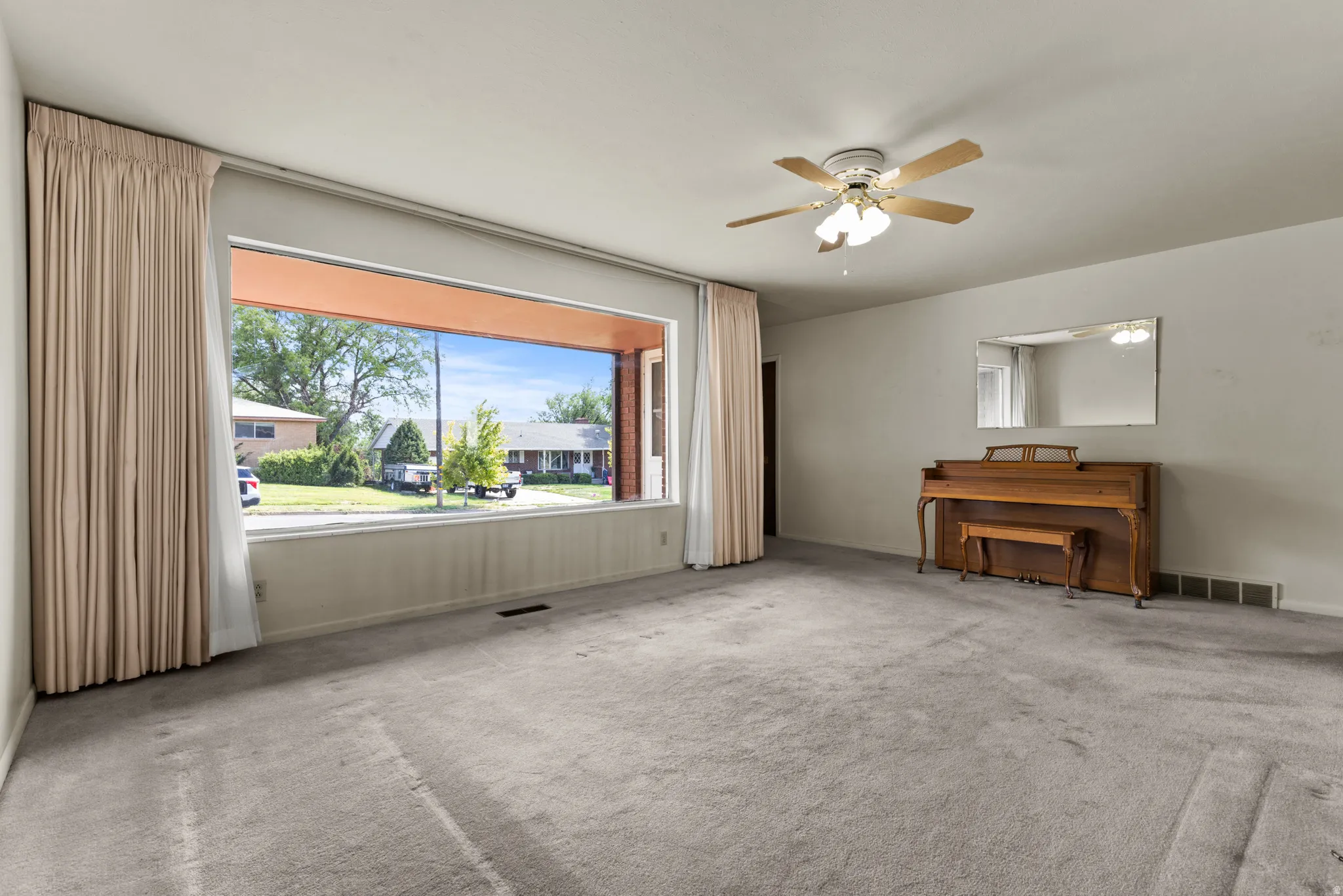 Expansive room with neutral carpeting and light-toned walls