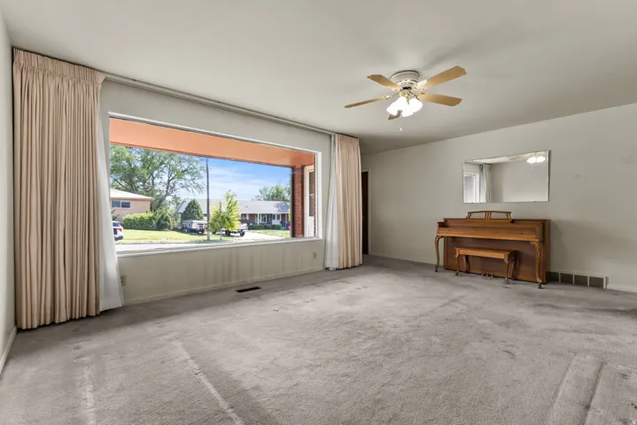 Expansive room with neutral carpeting and light-toned walls