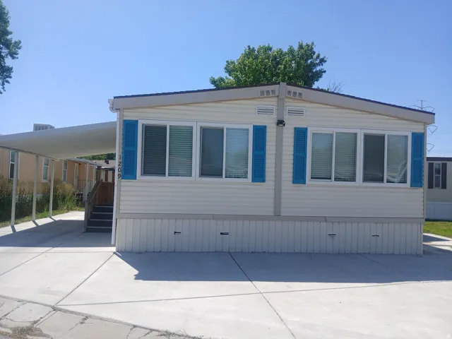 Light-colored siding with bright blue decorative shutters