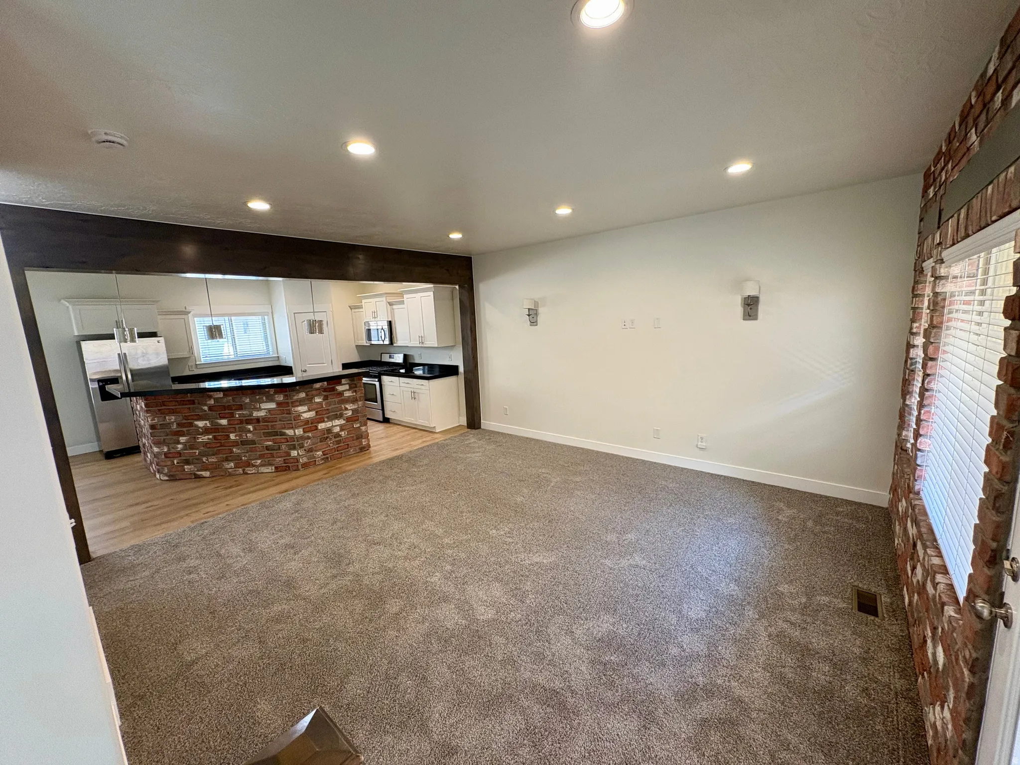 Open-concept living space featuring recessed lighting and wall sconces
