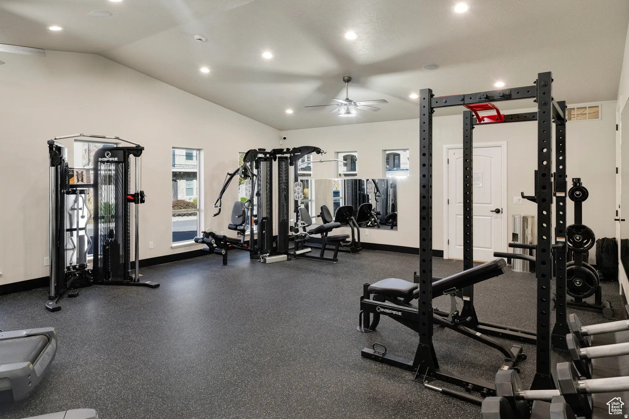 State-of-the-art fitness facility featuring multiple strength training stations, professional-grade equipment, rubber flooring, recessed ceiling lighting, and an open layout designed to accommodate comprehensive workout routines