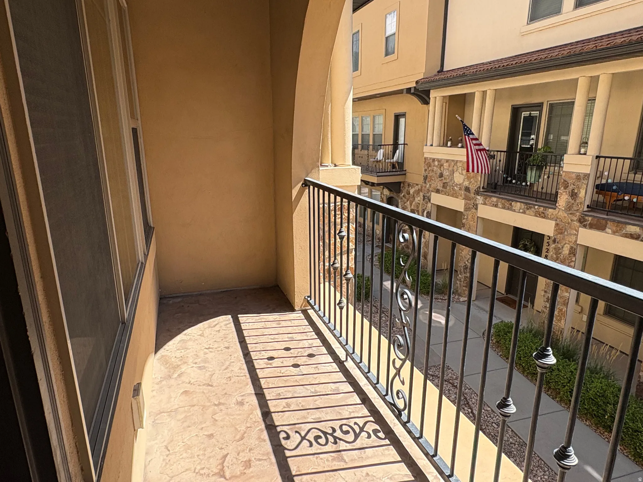 Balcony with decorative metal railing and stucco exterior