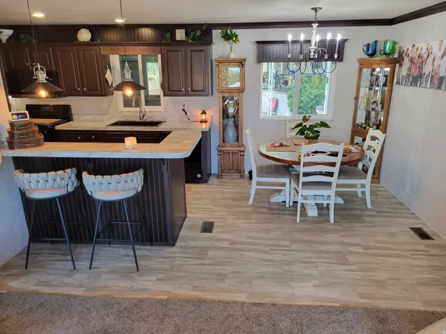 Kitchen with dark wood-finish cabinetry, light-toned countertops, and a built-in breakfast bar