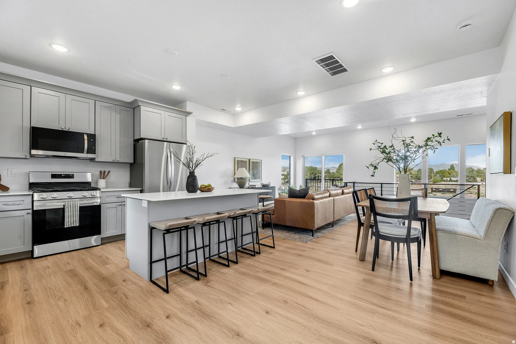 Open-concept floor plan featuring wood-finish flooring, recessed lighting, and large windows