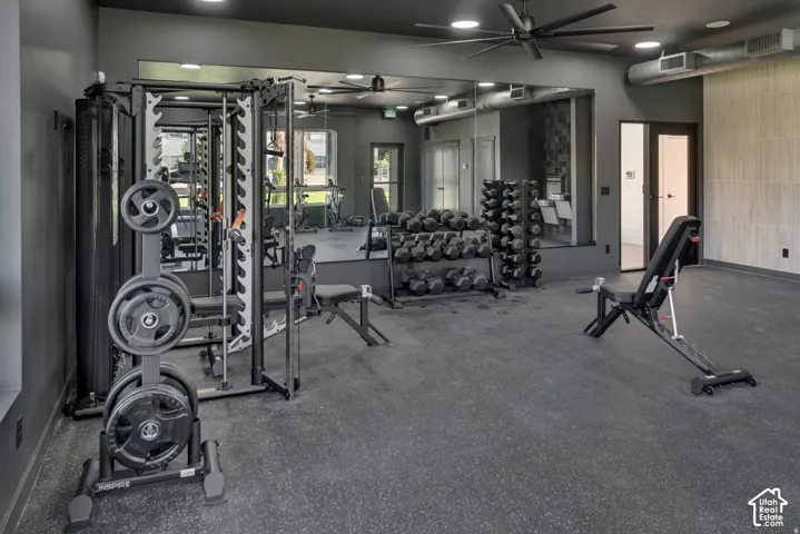 State-of-the-art fitness facility featuring a comprehensive cable machine system, stacked dumbbell rack with multiple weight options, stationary cycling equipment, and mirrored walls throughout