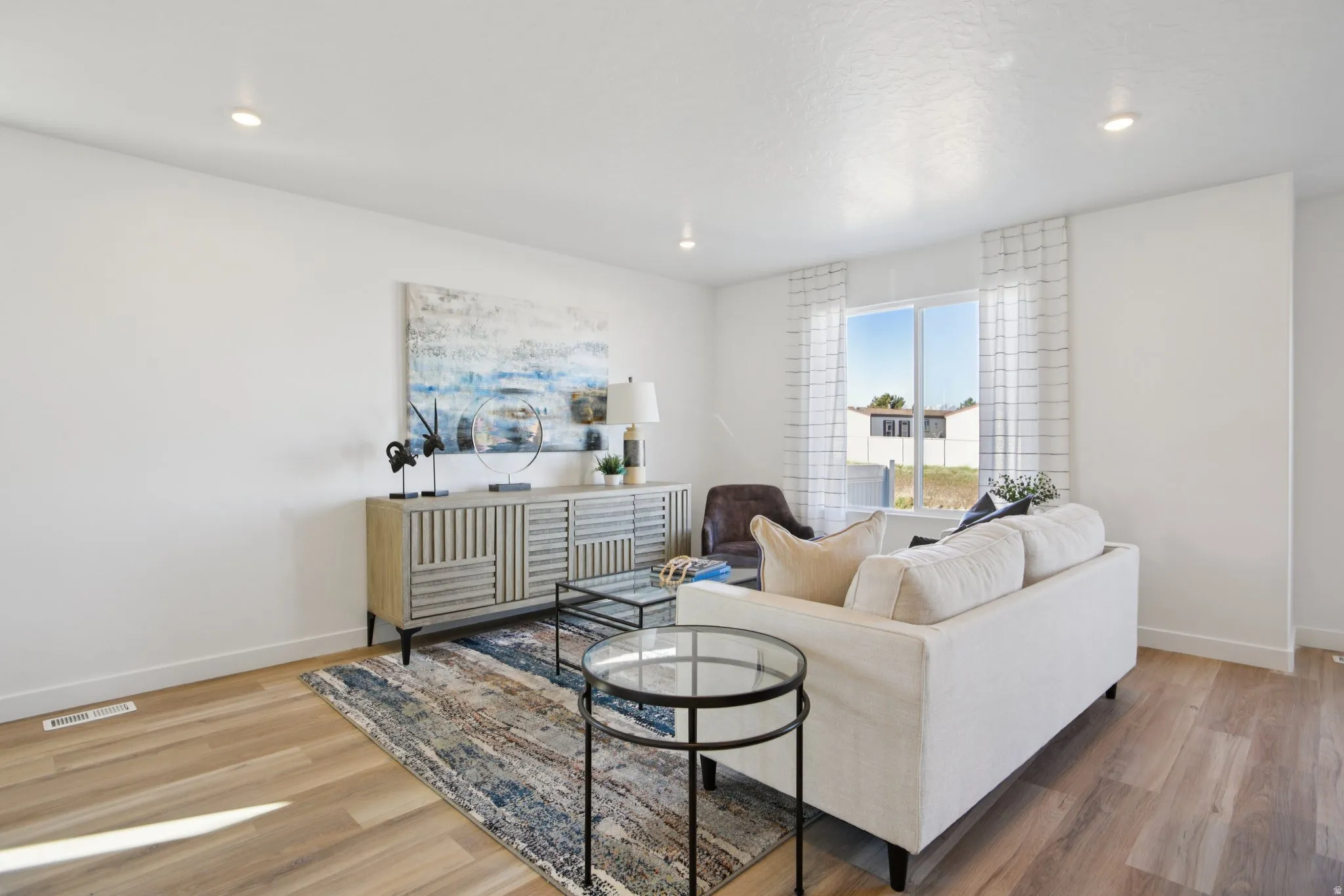 Recessed lighting, wood-finish flooring, large window, and a built-in sideboard