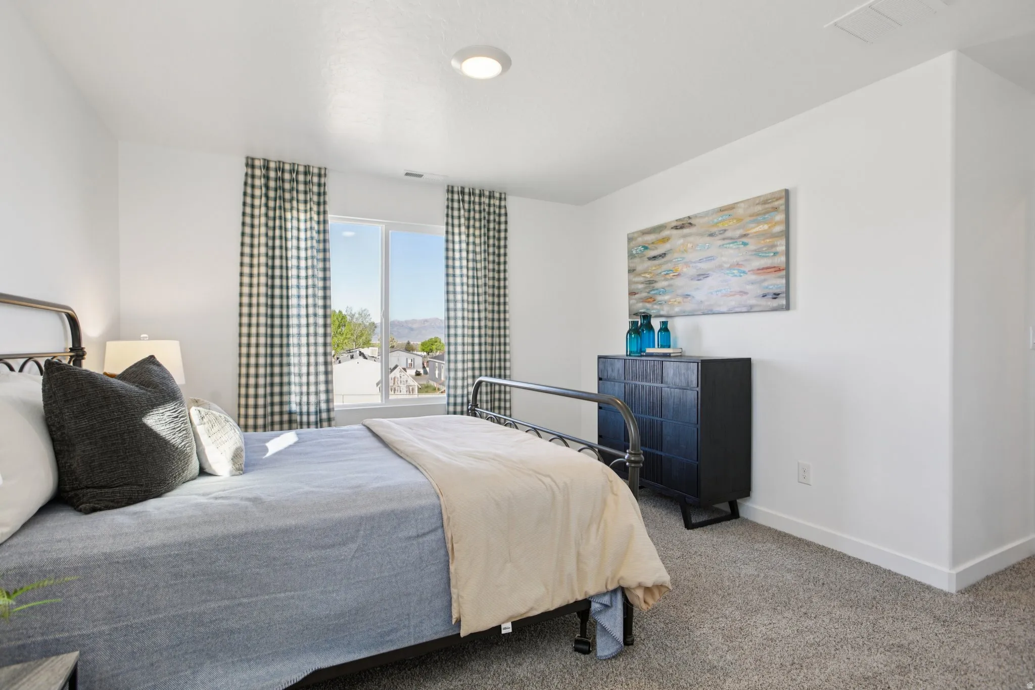 Wall-to-wall carpeting and a large window with ample natural light
