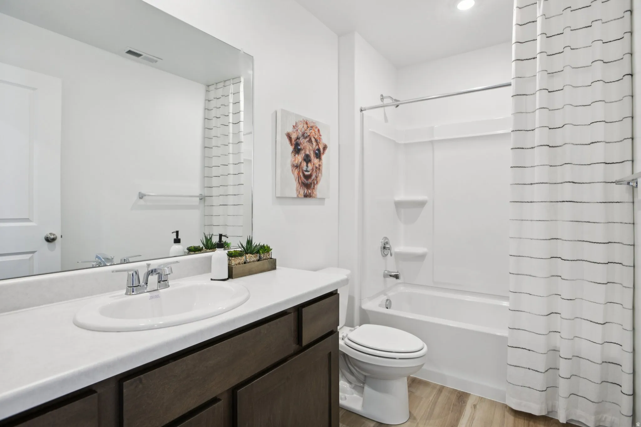 Integrated vanity with a single basin, chrome fixtures, and a large wall-mounted mirror