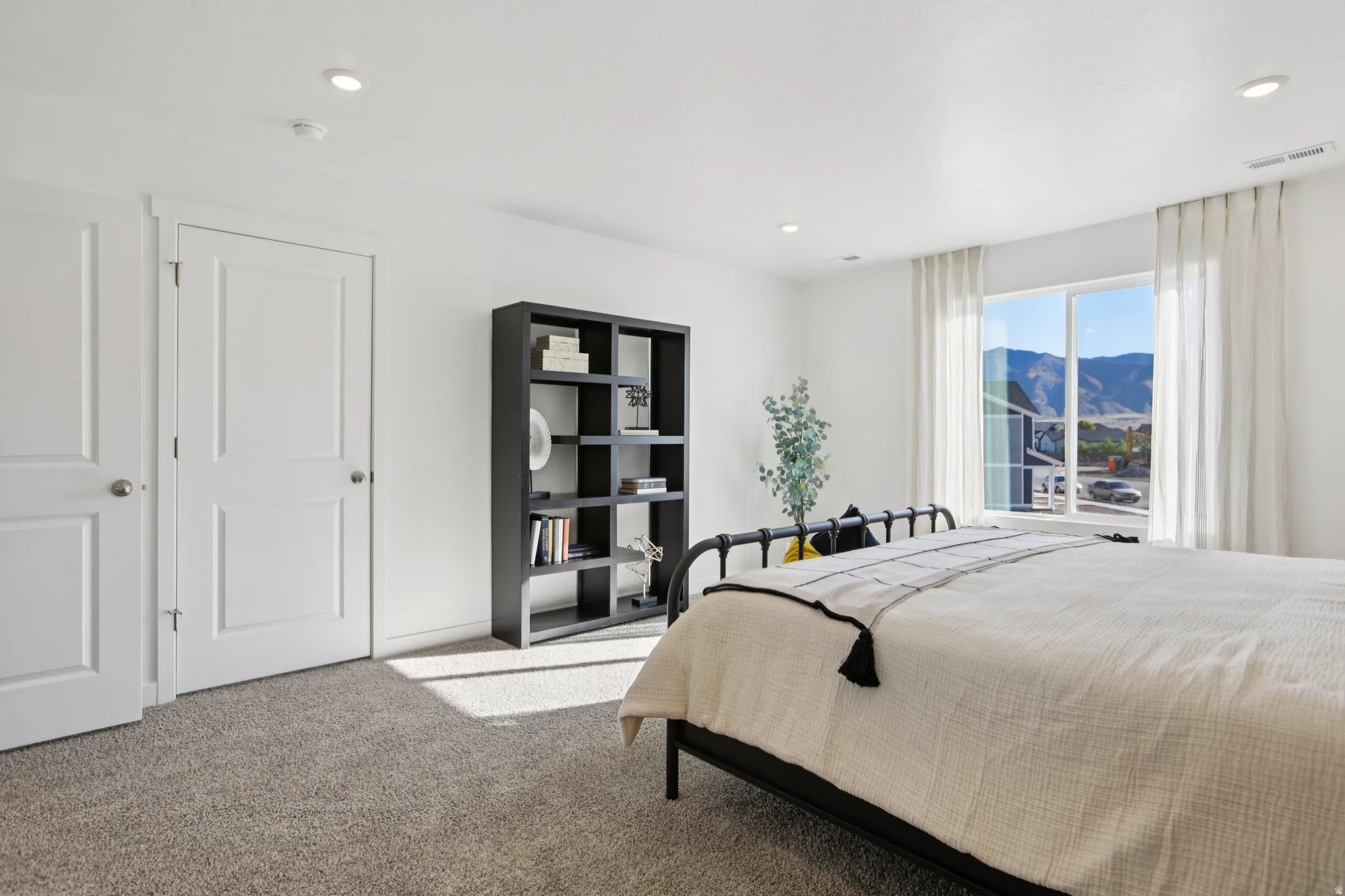 Recessed ceiling lighting, light-toned wall finishes, two-panel interior doors, and a large window