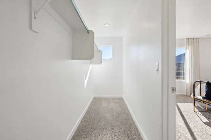 Walk-in closet with built-in shelving, hanging rod, and window