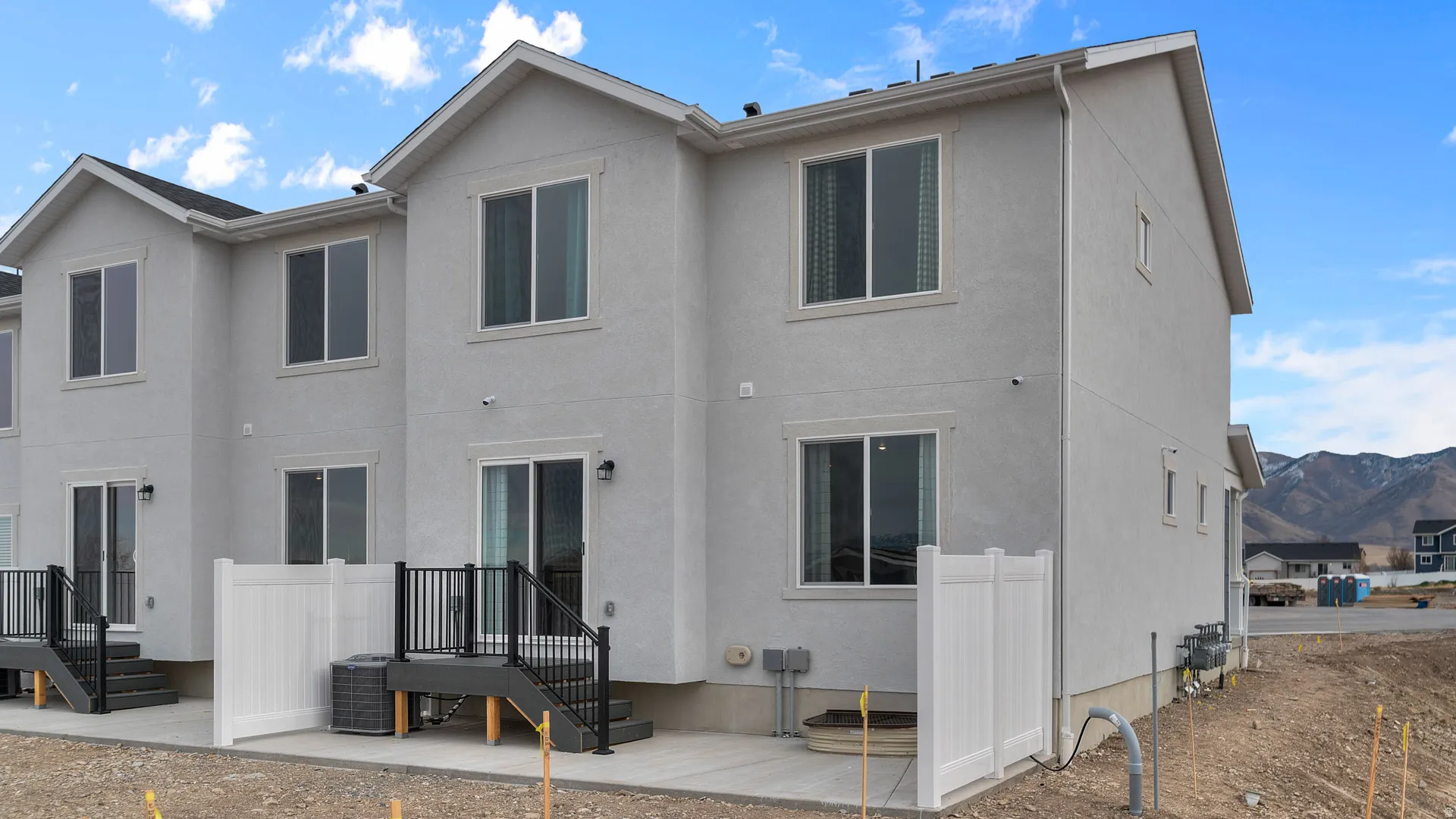 Stucco exterior with multiple windows, individual patio, and private fencing