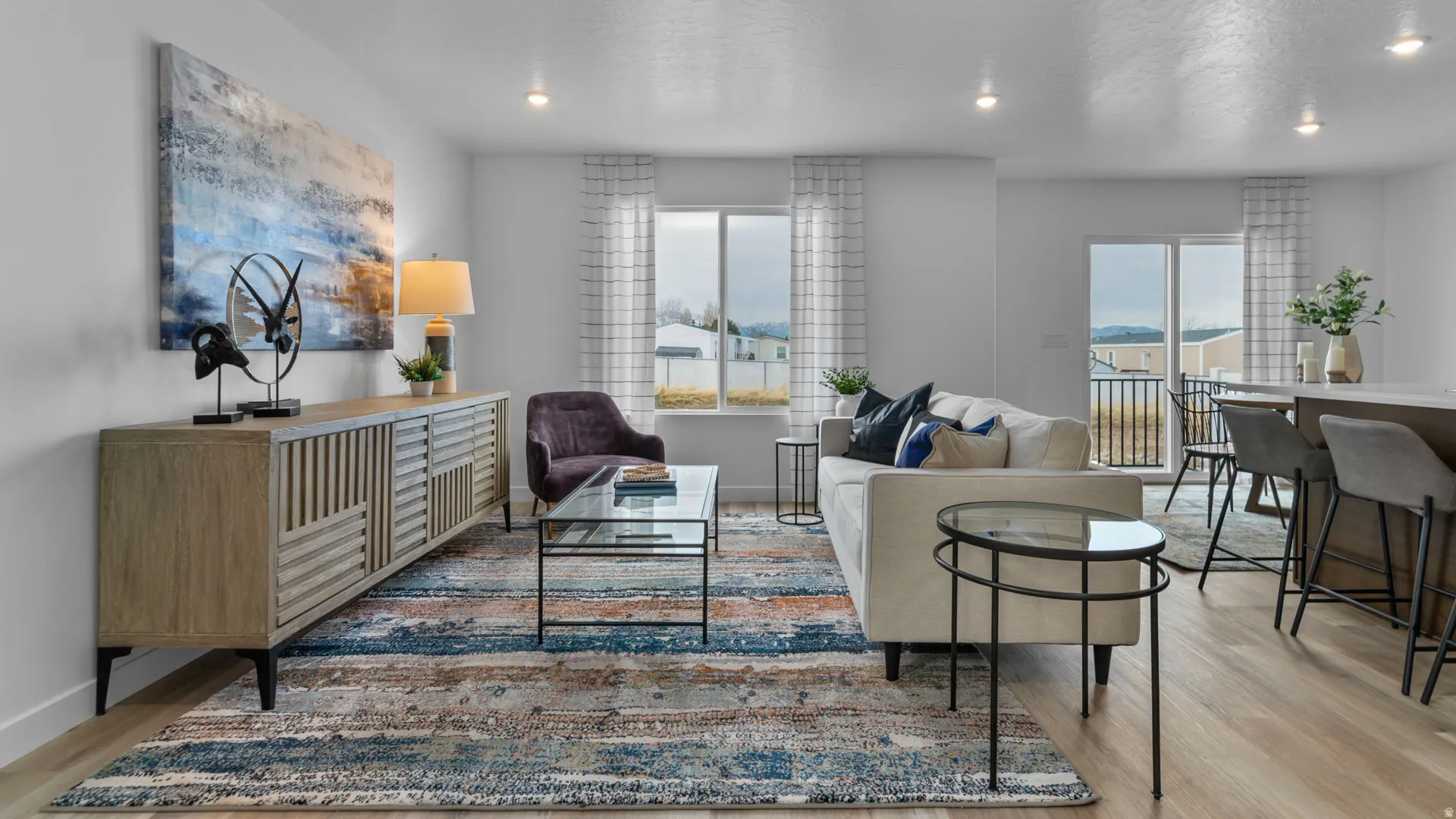Bright living area featuring wood-finish flooring, recessed lighting, and a sliding glass door