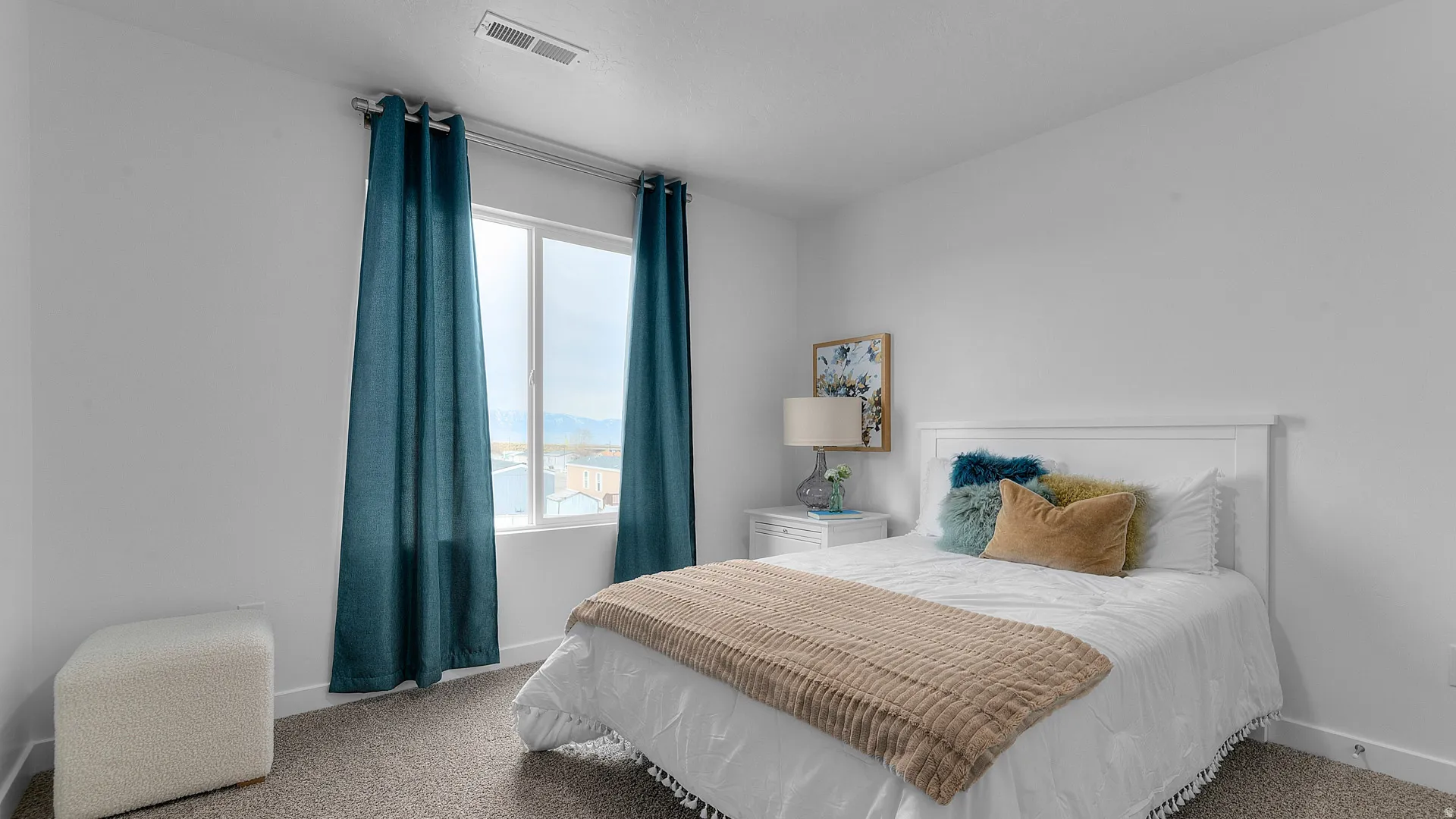 White walls, carpeted flooring, window with white frame, and a white headboard