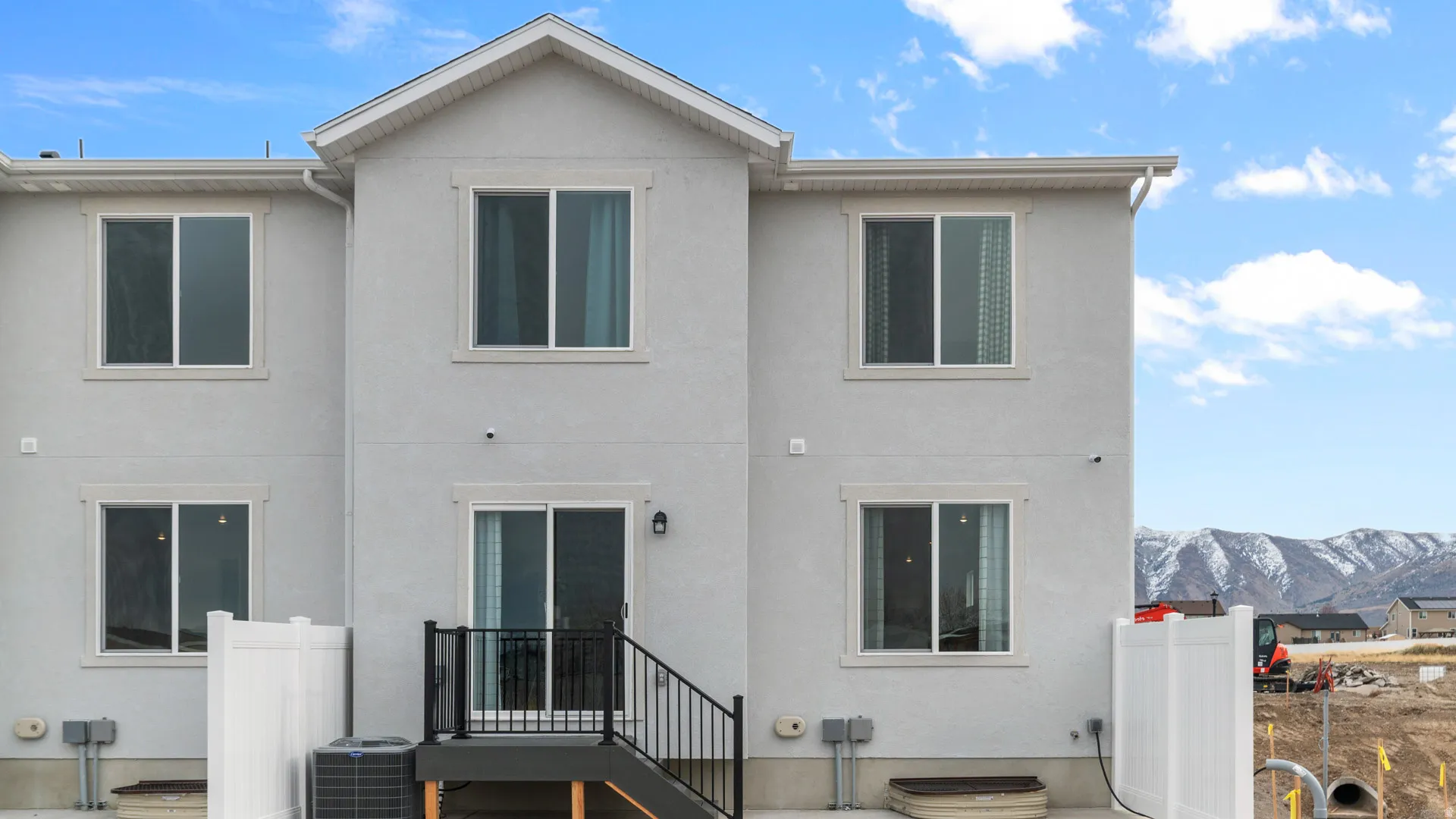 Light gray stucco exterior with white-framed windows