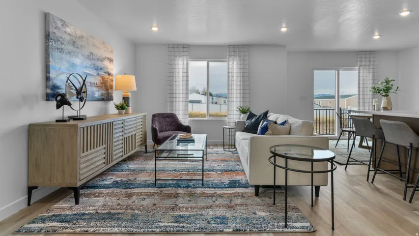 Bright living area featuring wood-finish flooring, recessed lighting, and a sliding glass door