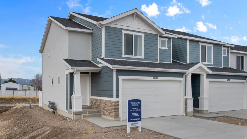 Modern exterior with horizontal siding, stone veneer accents, an attached garage, and a covered entry