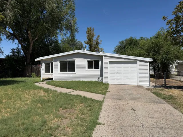 Single-story residence featuring light-colored siding, a white garage door, and a concrete driveway