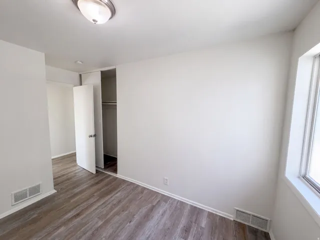 Wood-finish flooring, white painted walls, and a semi-flush mount ceiling light