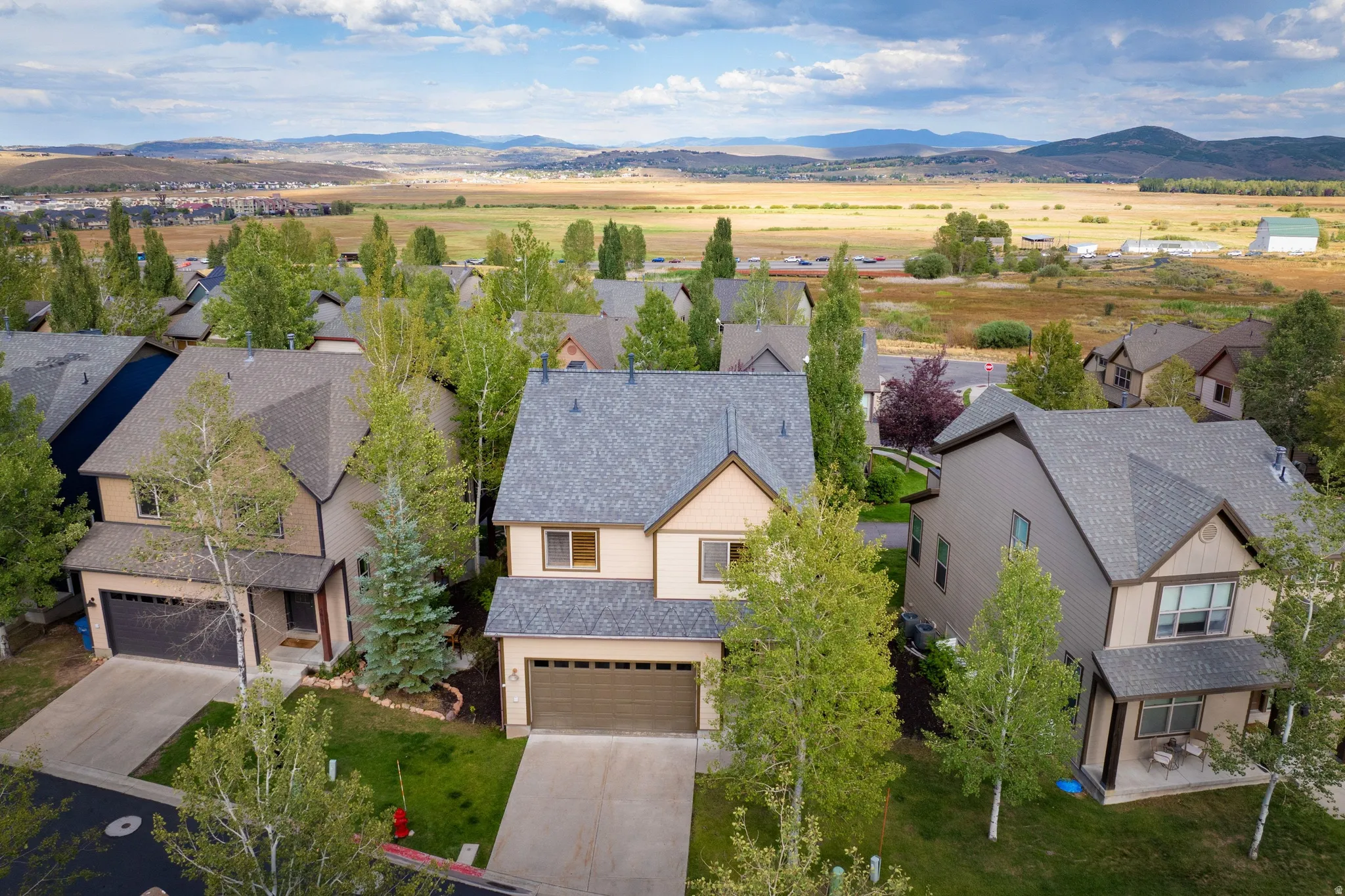 Elegant two-story residence featuring a composite shingle roof, multi-pane windows, and a two-car attached garage