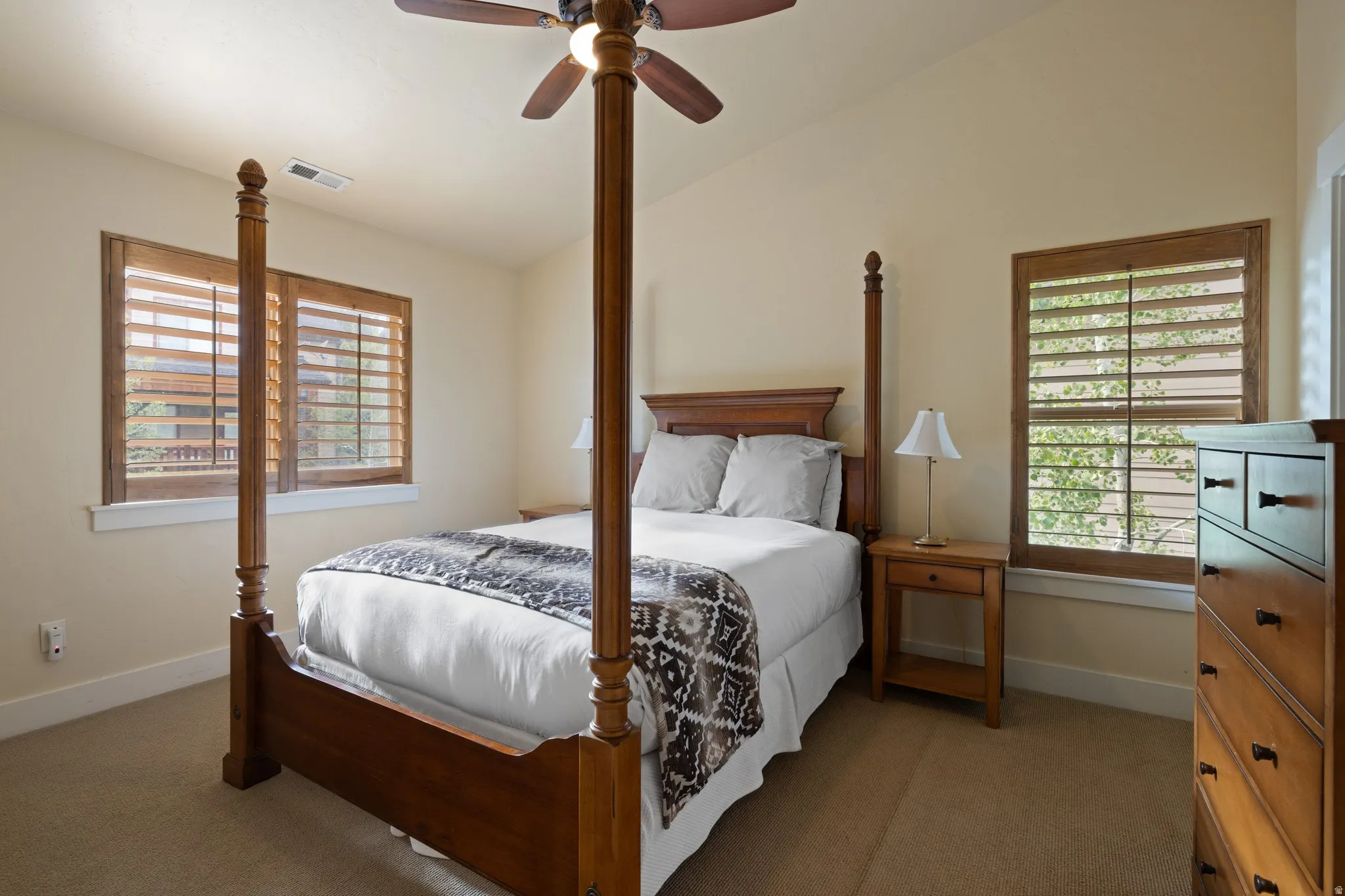Vaulted ceilings, a ceiling fan, and wood-finish window shutters