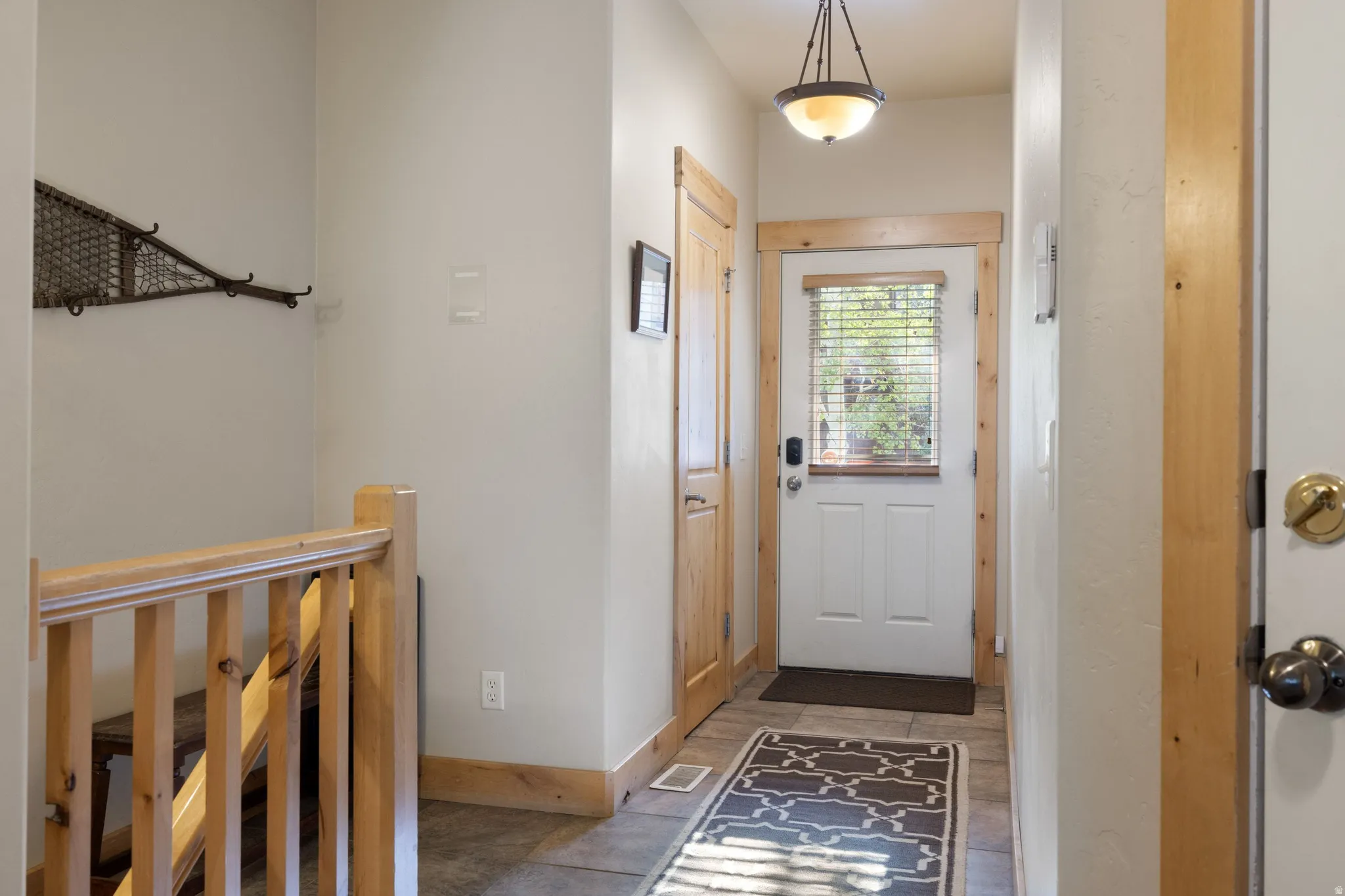 Entryway featuring a paneled door with a glass insert, wood trim, and a semi-flush mount light fixture