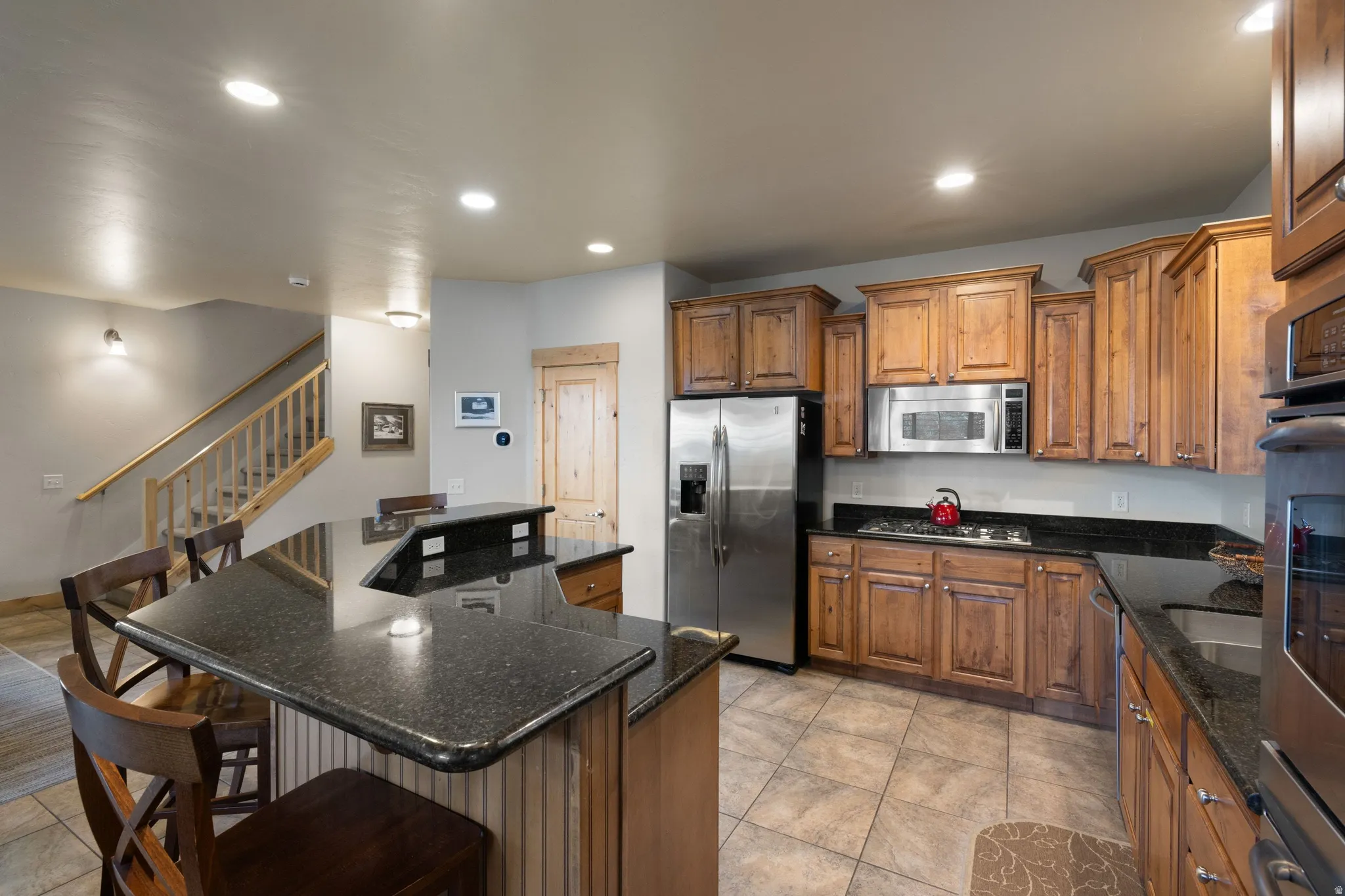 Spacious kitchen featuring wood cabinetry, stainless steel appliances, and a large center island with seating