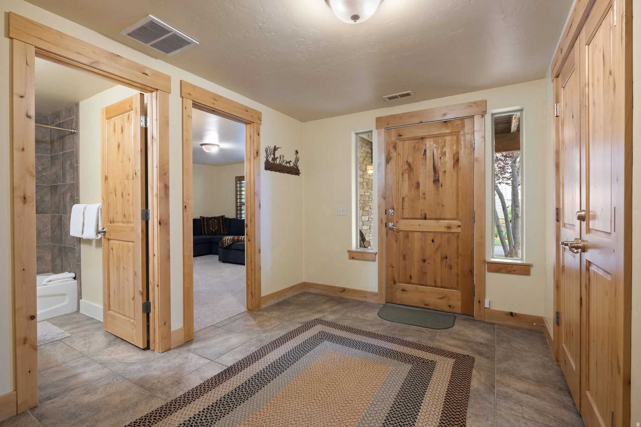 Entryway featuring tile flooring, natural wood doors, and side windows