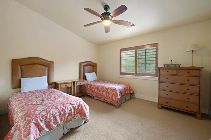Vaulted ceiling with a ceiling fan, window with wood shutters, and carpeted flooring