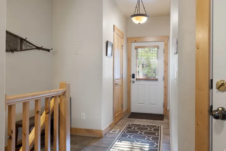 Entryway featuring a paneled door with a glass insert, wood trim, and a semi-flush mount light fixture