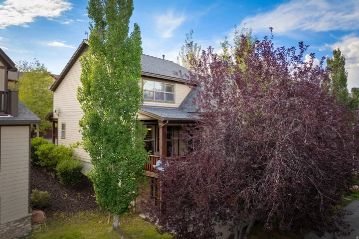 Two-story home featuring a charming brick and siding exterior with a peaked roofline