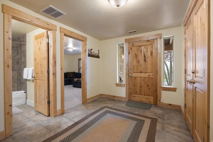 Entryway featuring tile flooring, natural wood doors, and side windows