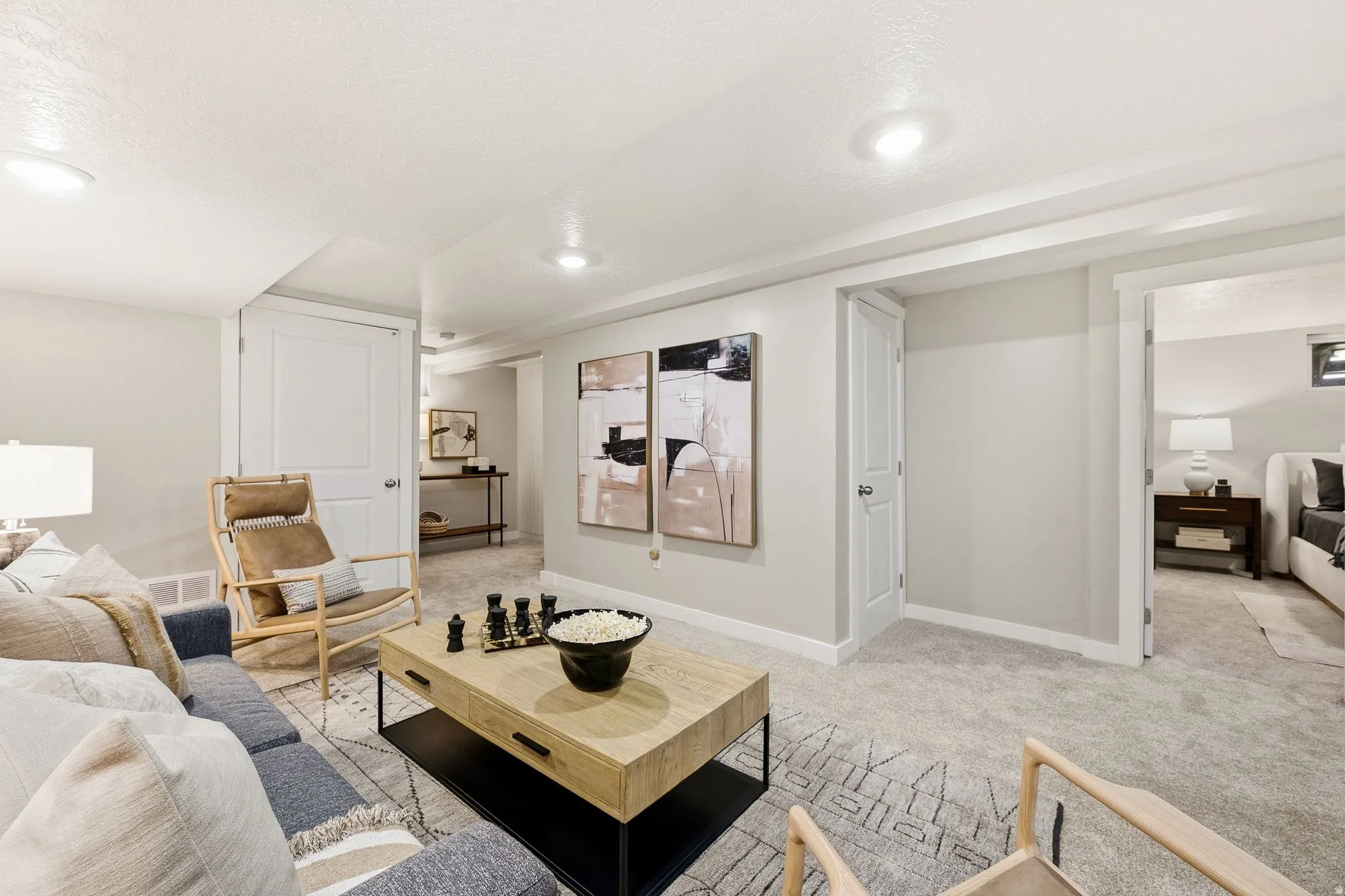 Recessed lighting, wood-finish coffee table, light gray walls, white trim, and carpet flooring
