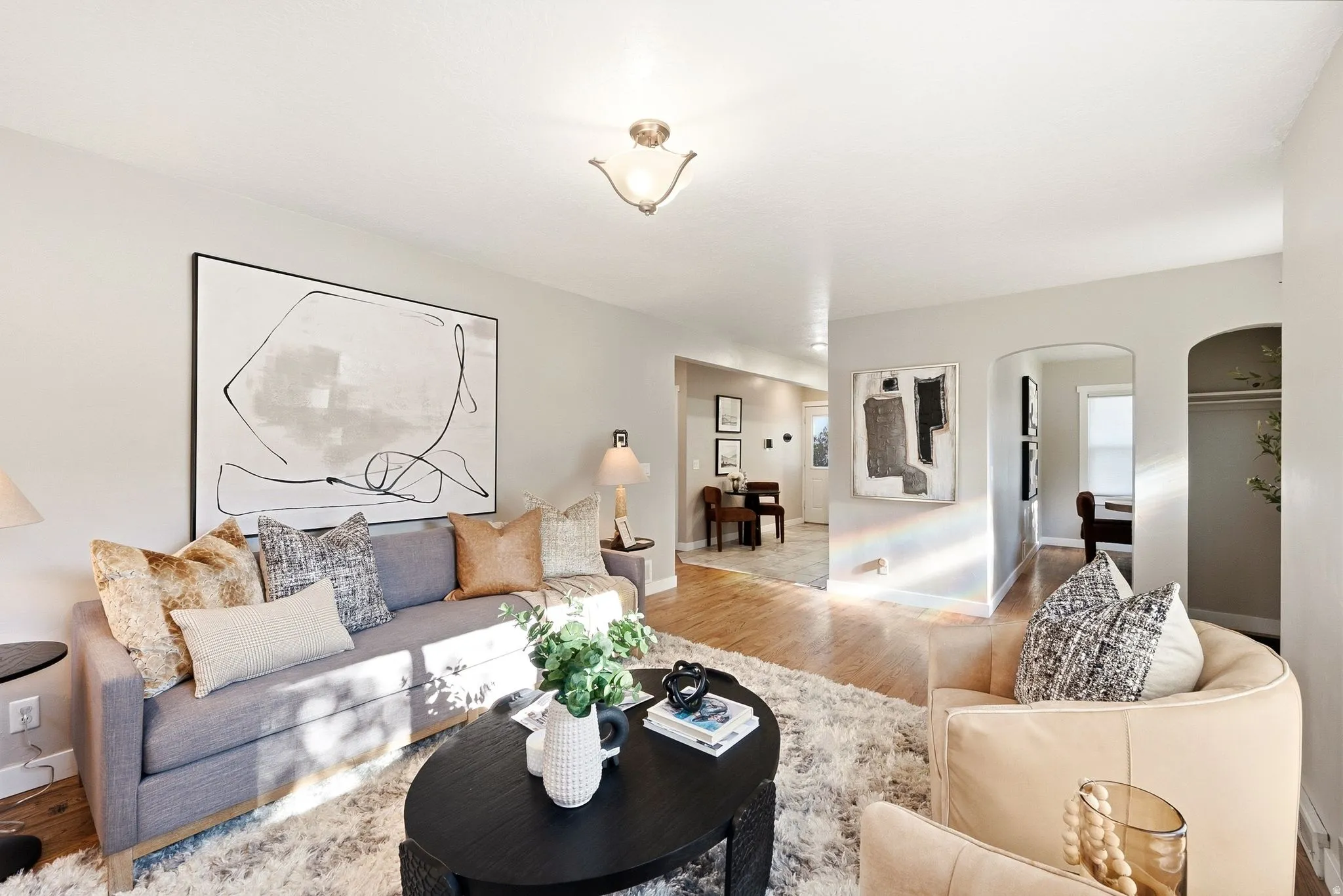 Bright, open living spaces featuring wood-finish flooring throughout, a neutral color palette, and abundant natural light