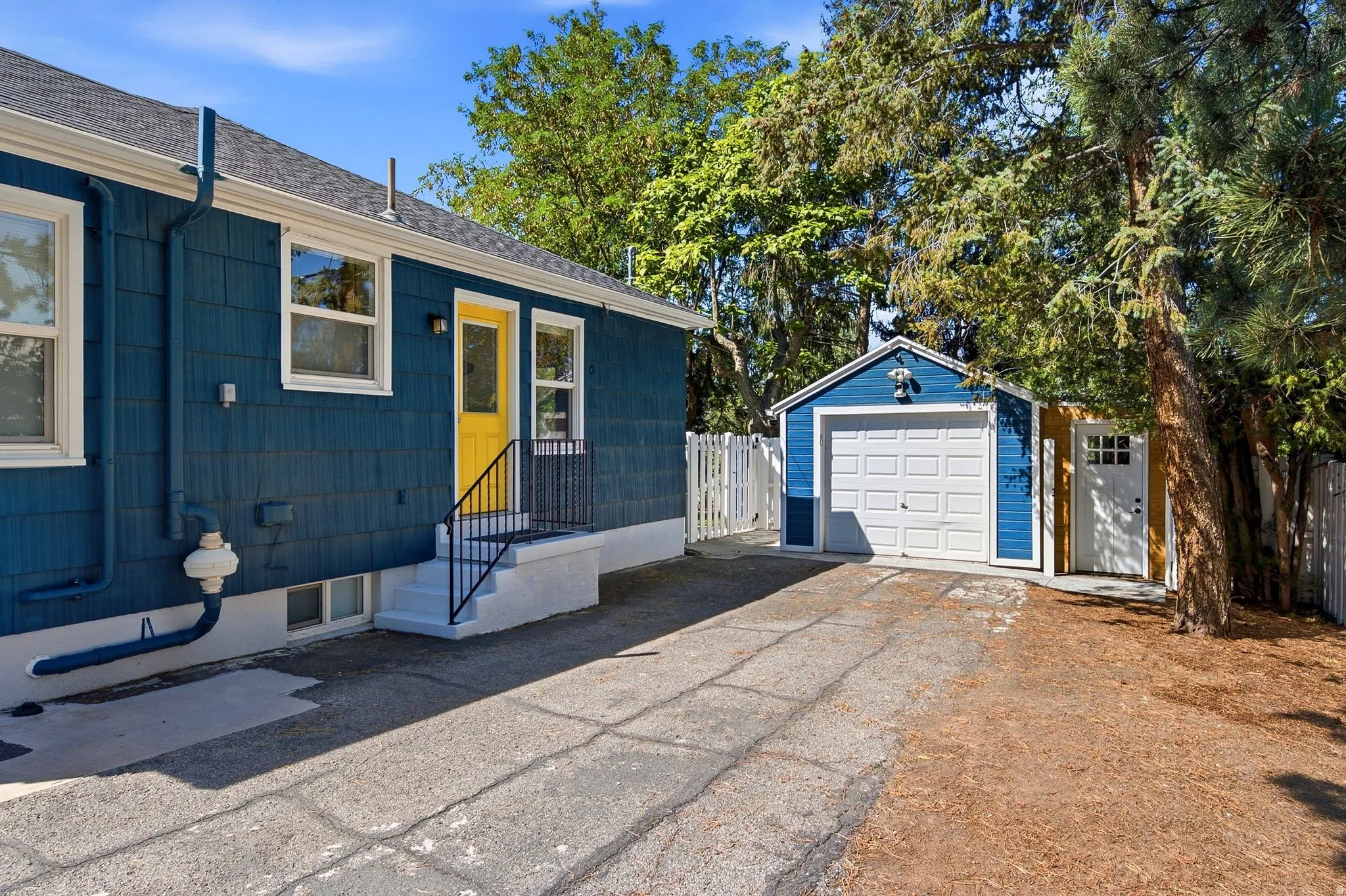 Side entrance of home, driveway, garage and attached bonus space/flex space.