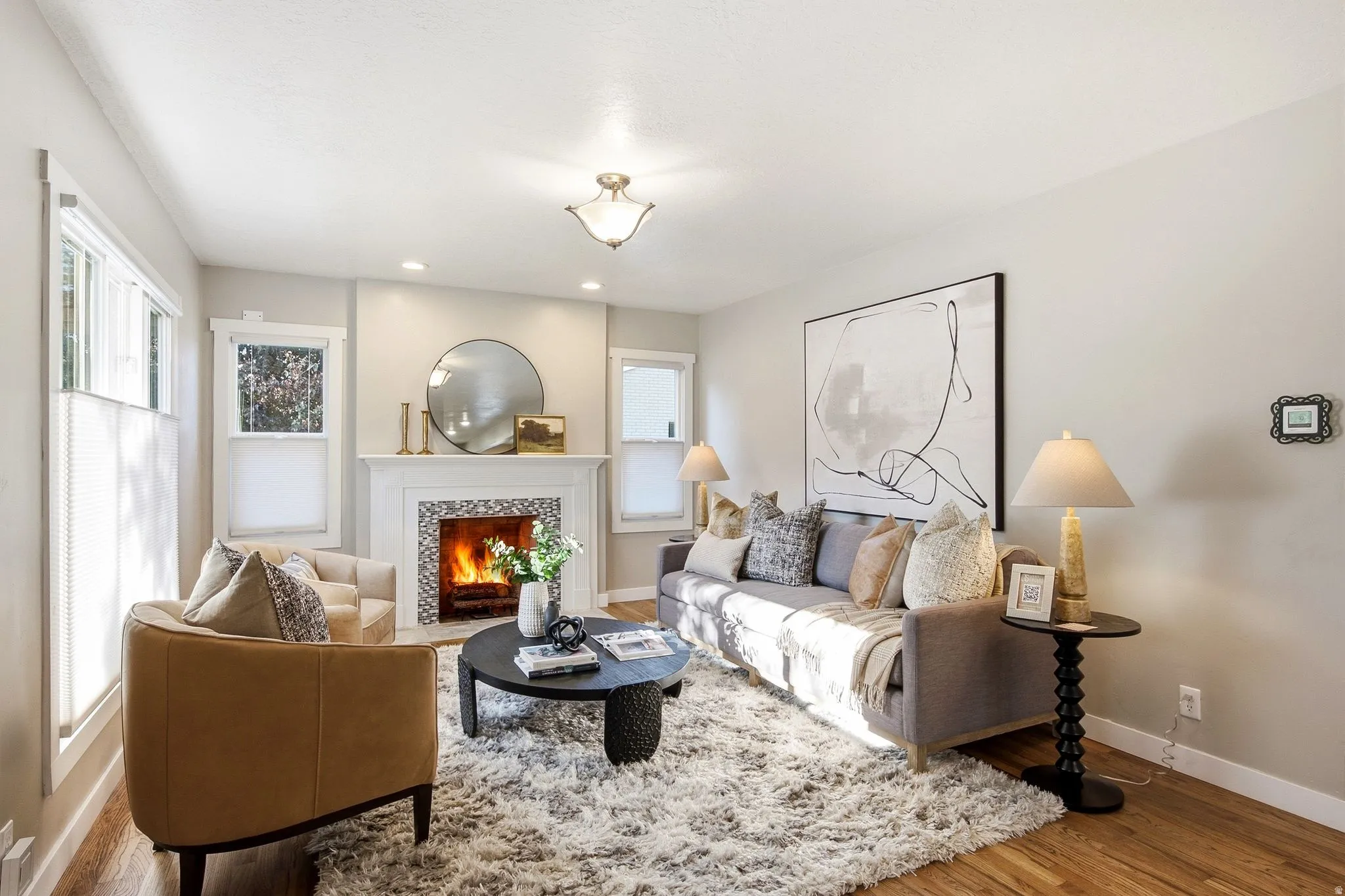 Elegant living room anchored by a wood-burning fireplace with built-in shelving and a decorative mirror